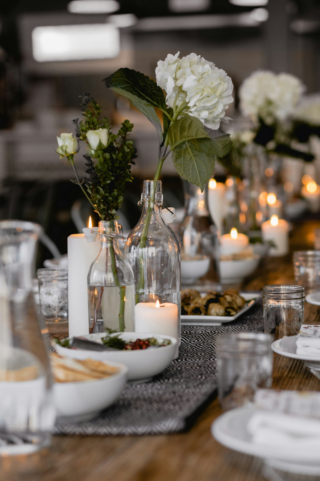 A long dining table prepared for the group with candles, linens and quiet staging