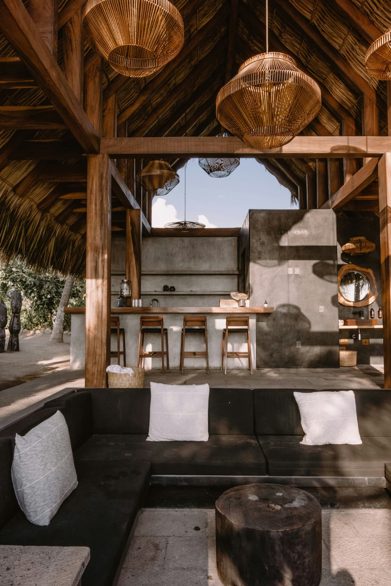 A boutique retreat interior with warm wood, rattan lanterns and considered architecture