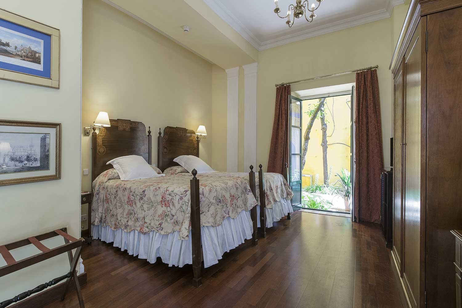 A simple twin room with two beds and shuttered windows